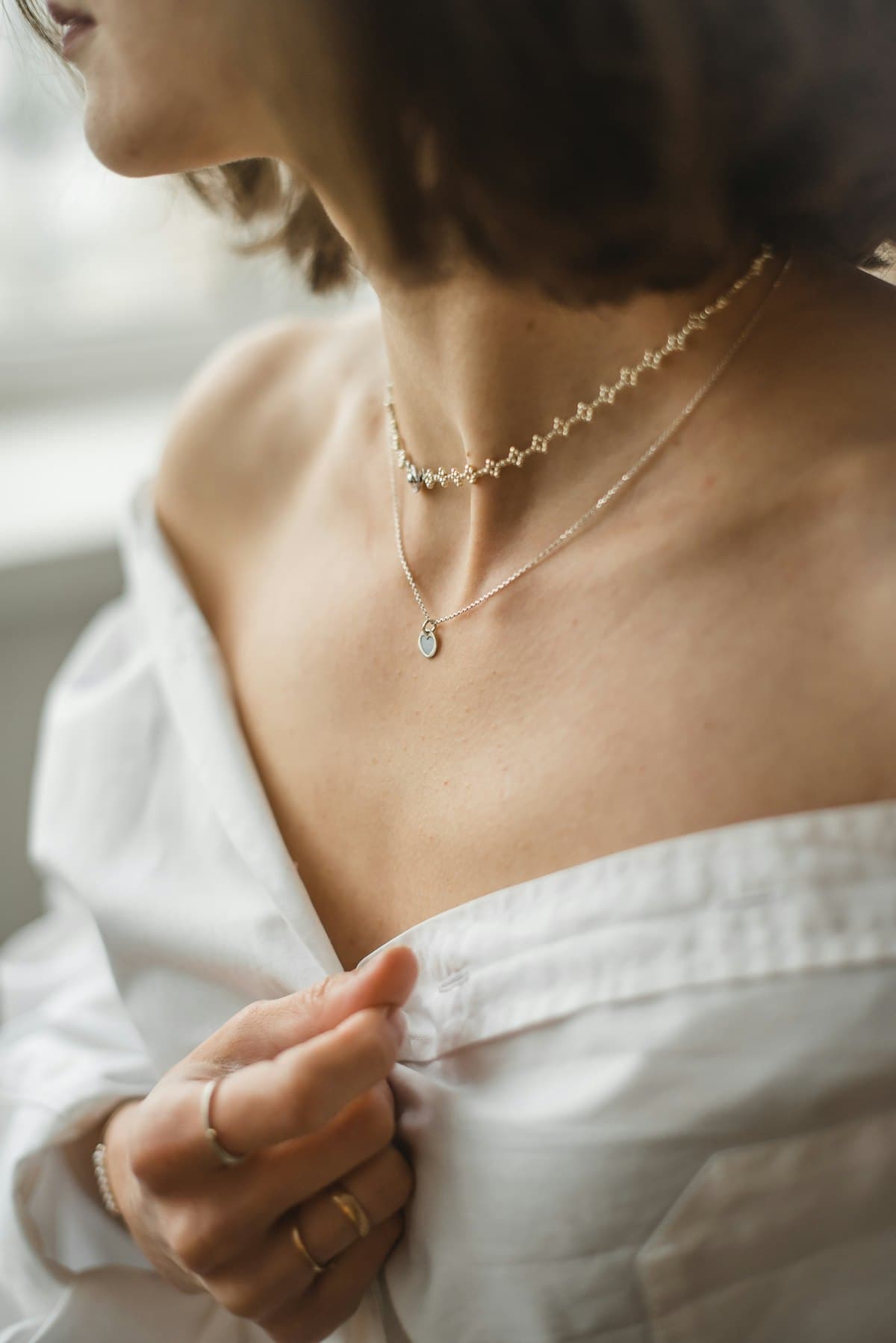 Femme portant des colliers et bagues fins