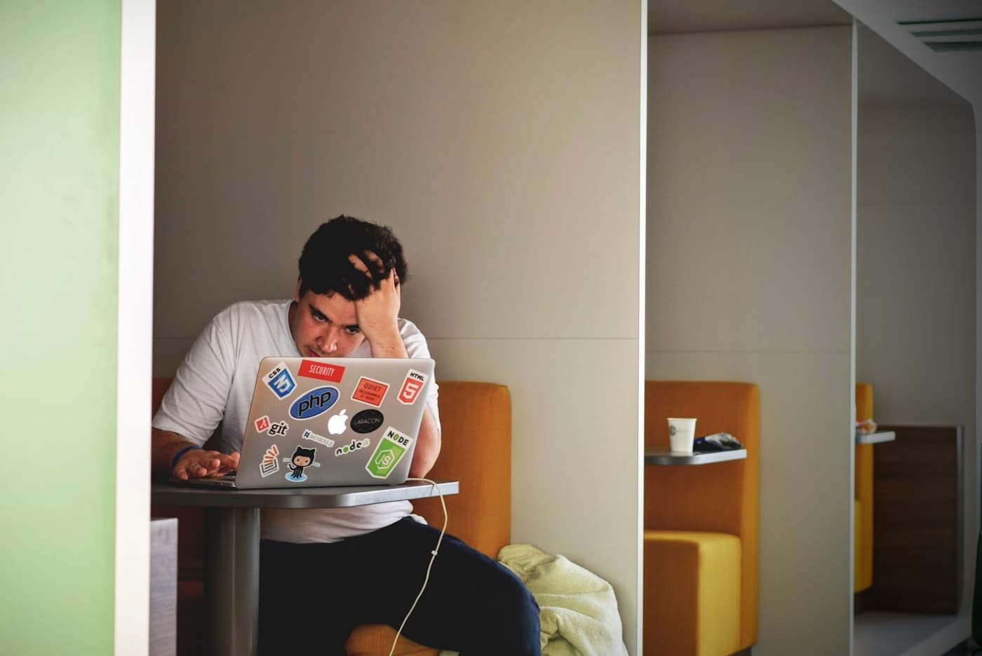 Un e-commerçant découragé, la tête dans la main devant son ordinateur portable