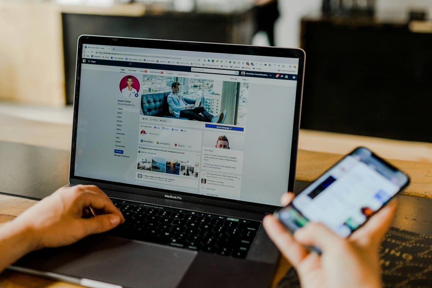 Un ordinateur portable ouvert sur Facebook et une main tenant un smartphone