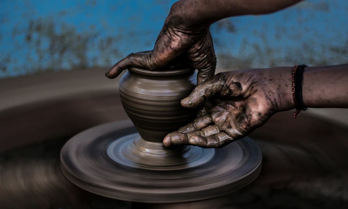 Mains façonnant une poterie au tour